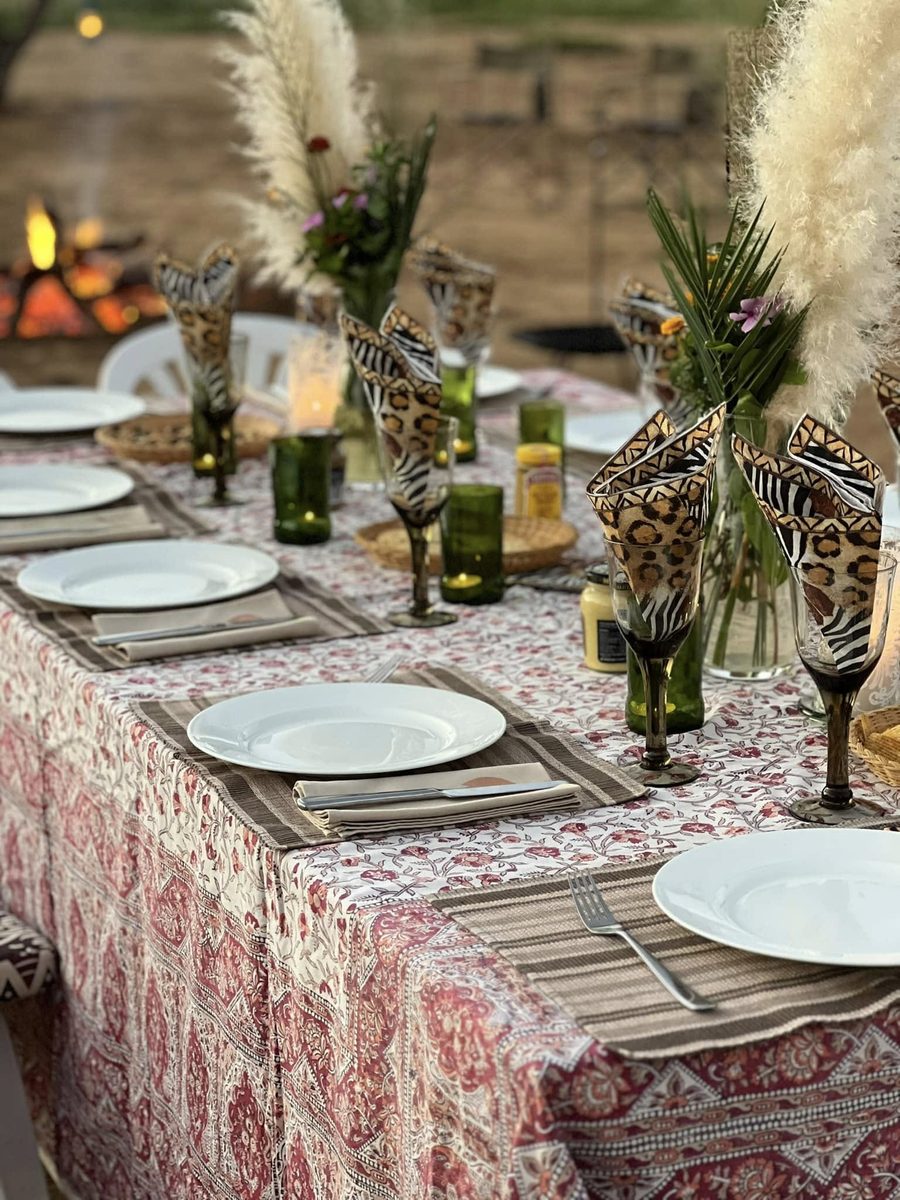 A table laid in the bush with pampas grass and candles