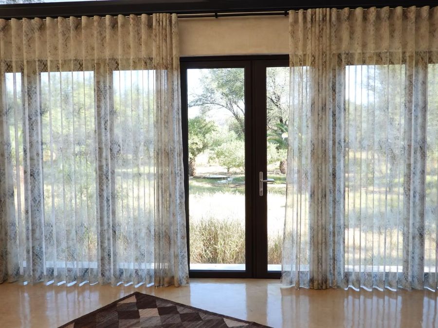 View from the bed through the curtains to the bush