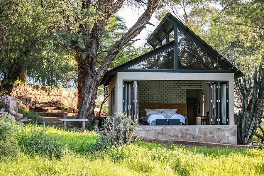 A cottage with its glass front open to the garden in daylight