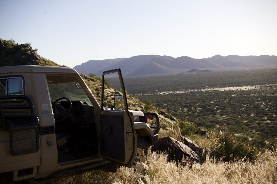 The game-drive vehicle parked high above the plains in the evening light